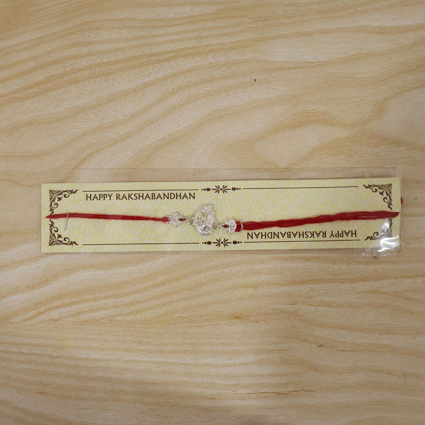 Close-up of the oxidised silver Krishna motif on Rakhi with decorative beads