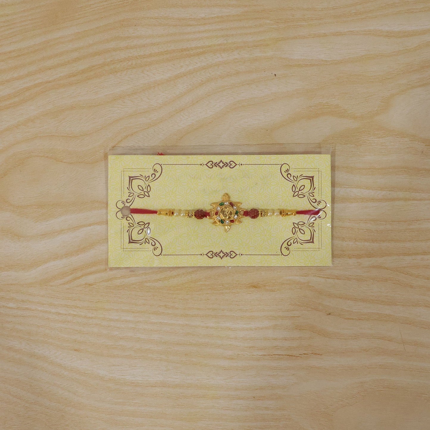 Stylish golden tortoise Om rakhi resting on a traditional festive background