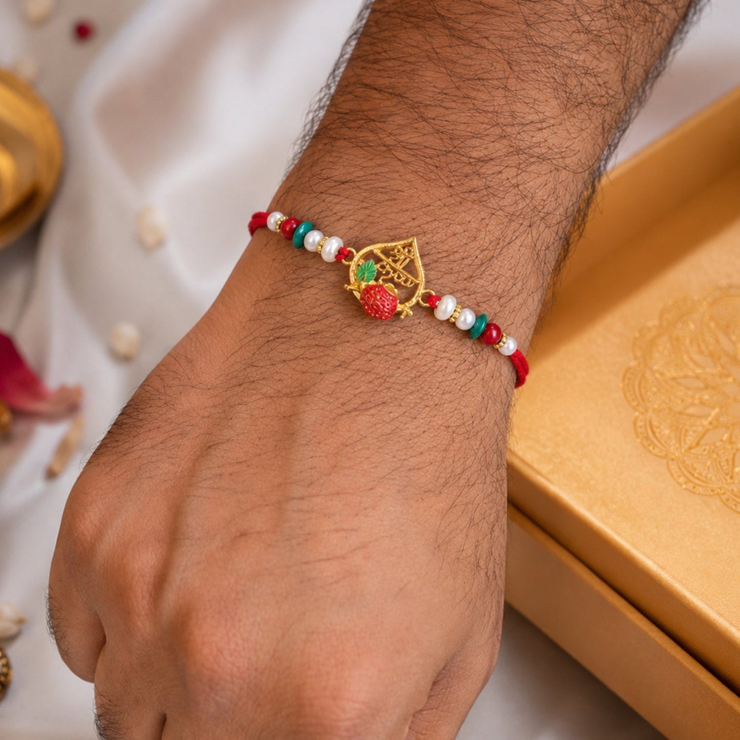 Close-up of Golden Veer Meenakari Heart Rakhi decorated with pearls for Raksha Bandhan