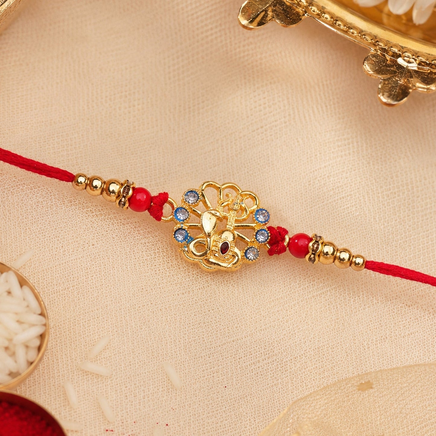 Stylish blue and red stones God Charm Rakhi for brother