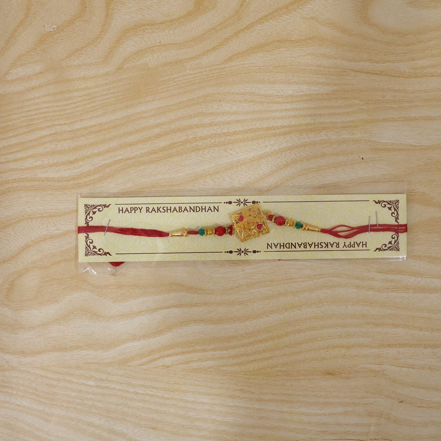 Close-up of traditional designer rakhi with pink stones and colorful beads