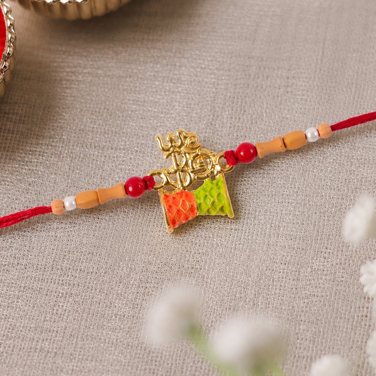 Close-up of the golden Om charm and colourful kite detail on the Rakhi.
