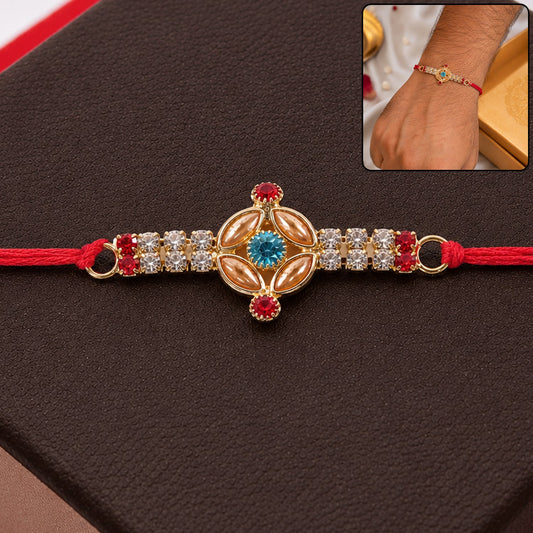 Close-up of a detailed gold Kundan Rakhi with turquoise stone and American Diamonds, showcasing craftsmanship.