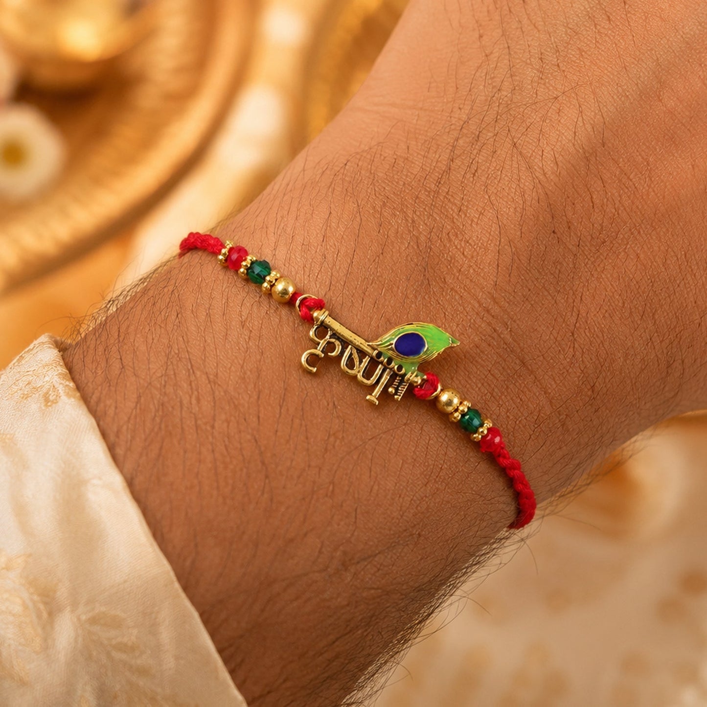 Lord Krishna Rakhi showcasing vibrant peacock feather on a traditional thread.