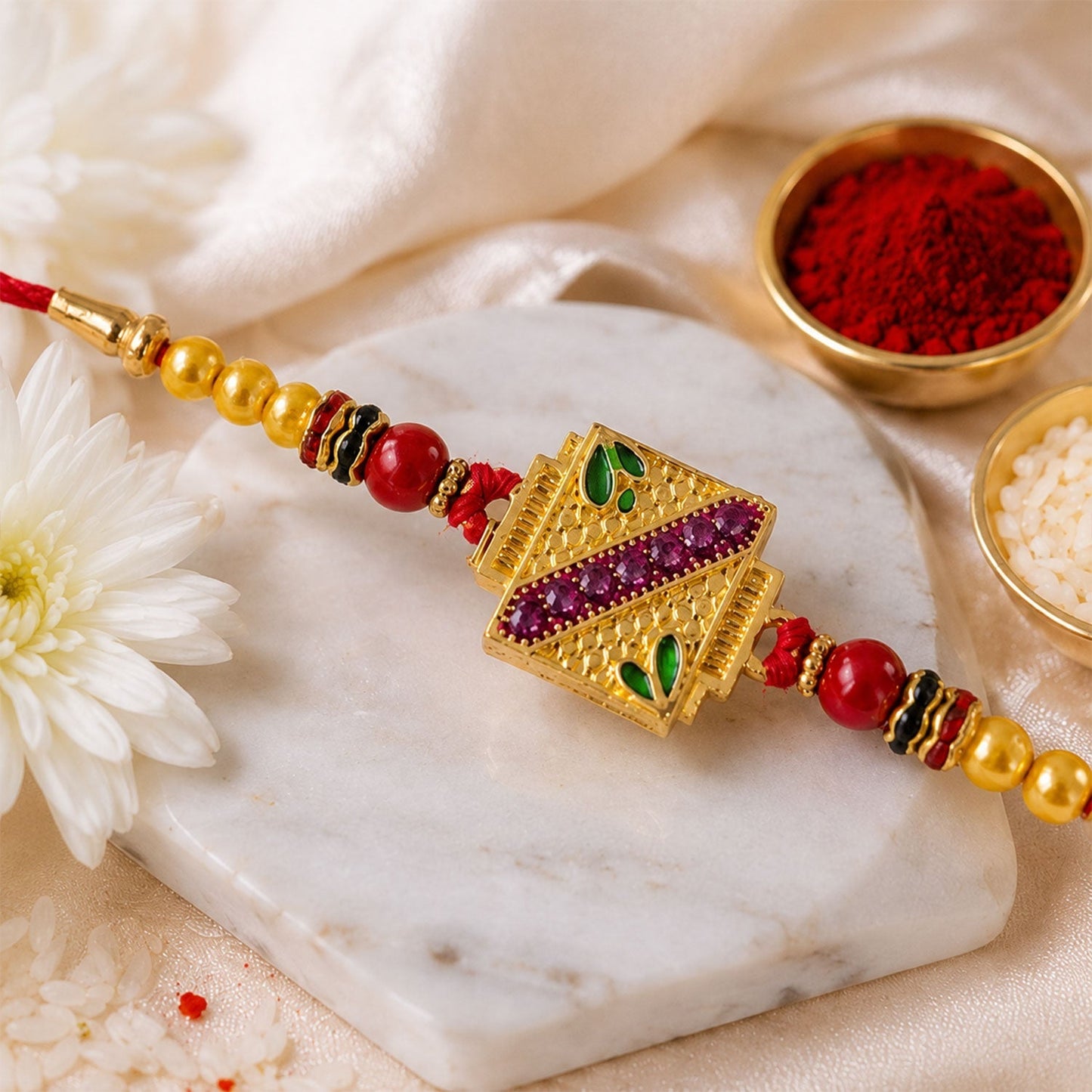 Top view of a traditional Meenakari Rakhi with intricate golden square work.