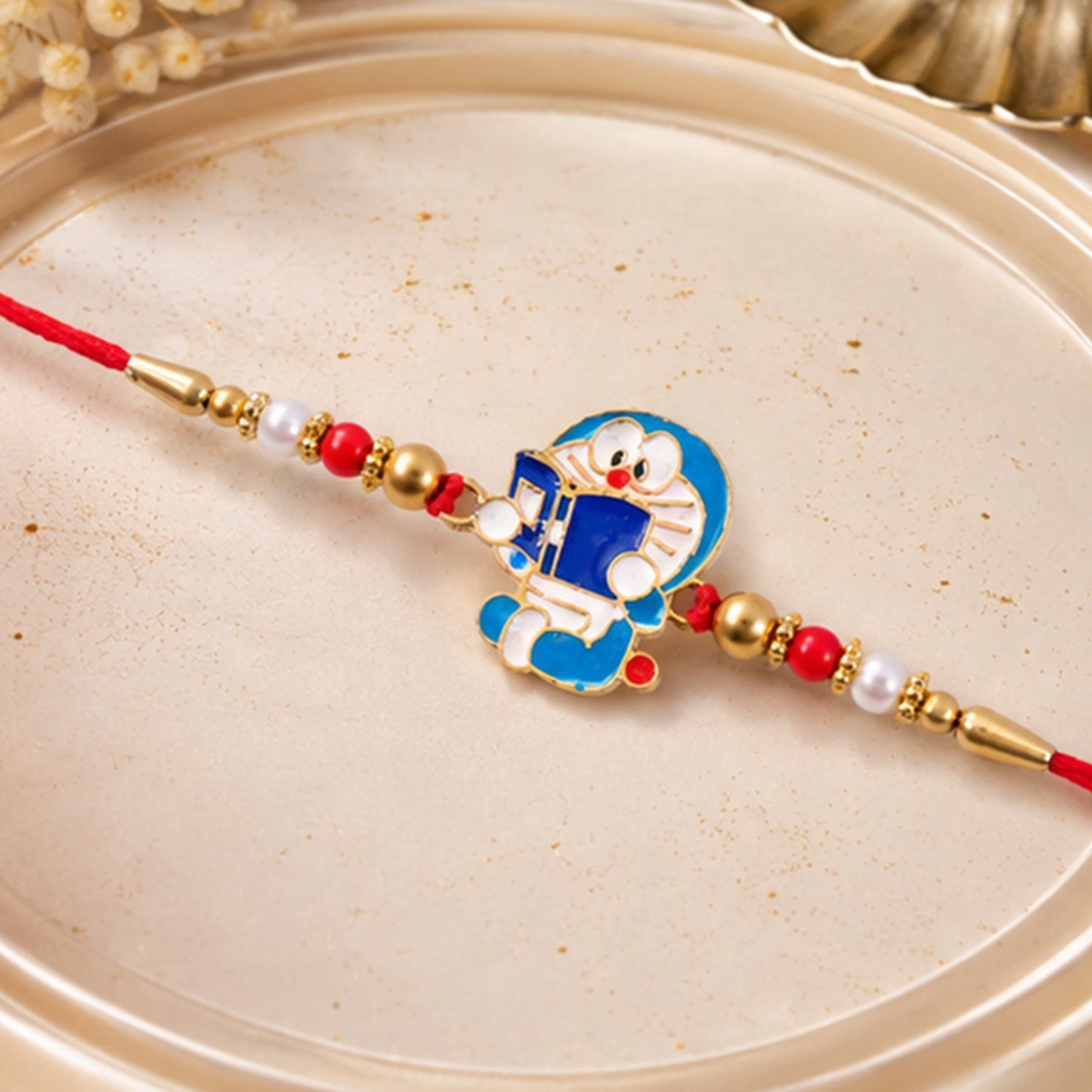 Side perspective highlighting playful design of the Doraemon rakhi.