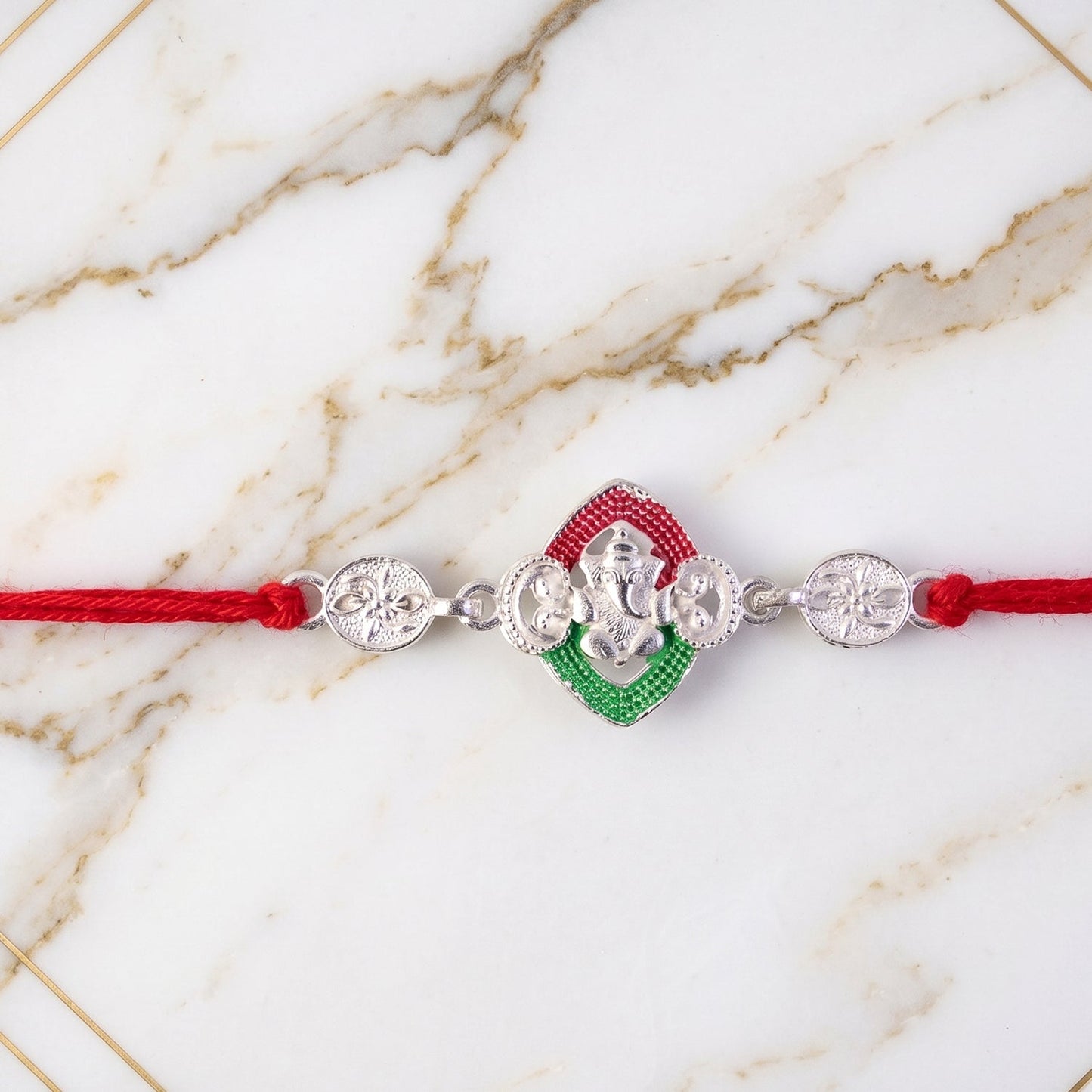 Top view of the vibrant Ganesha Meenakari Rakhi highlighting rich colours.
