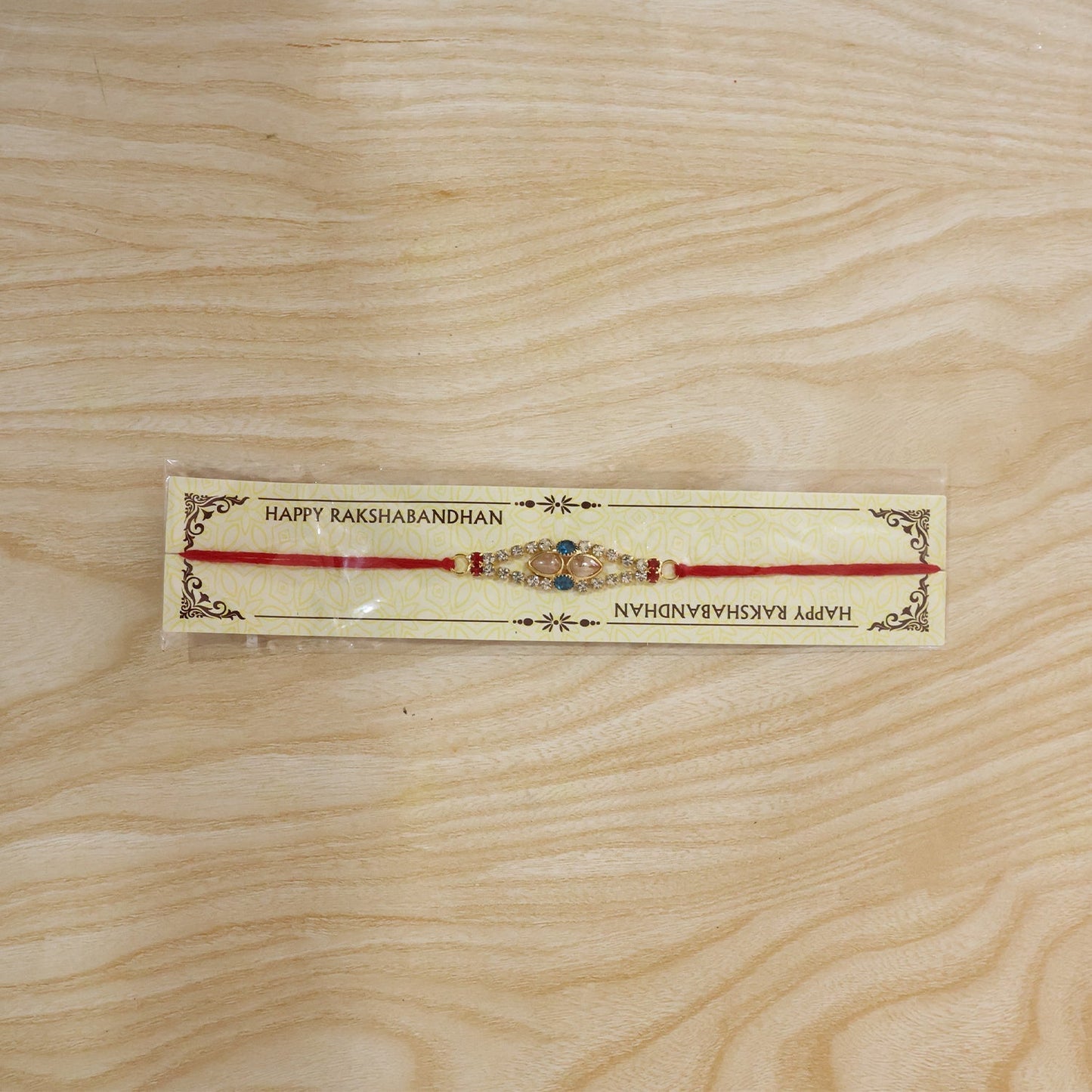 Different angle of Royal Pearl AD Stone Rakhi with blue and red accents.