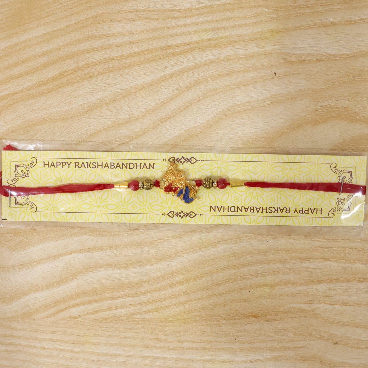 Beautiful Golden Peacock Rakhi with blue enamel and red beads for Raksha Bandhan