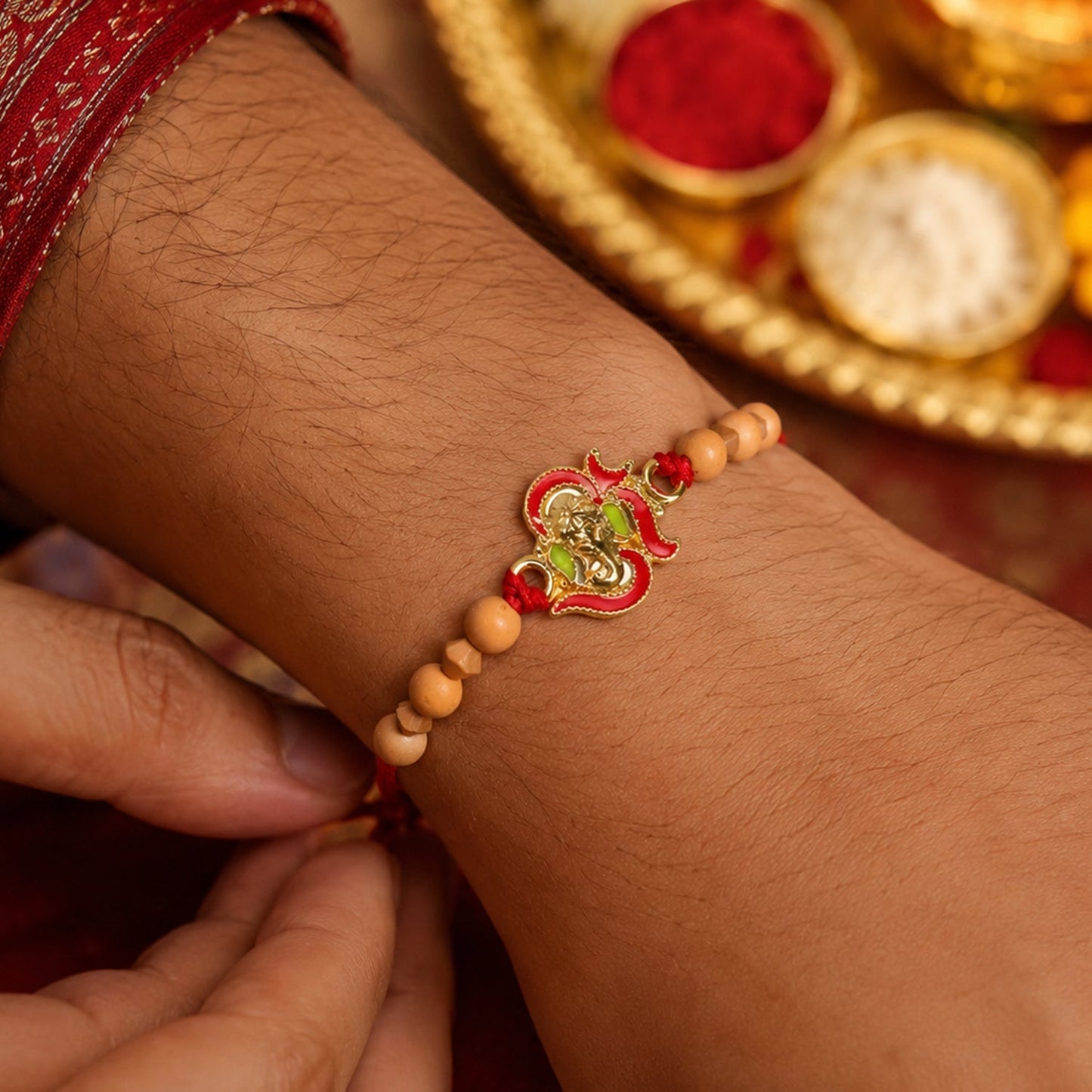 Traditional Lord Ganesha Rakhi with intricate thread work.
