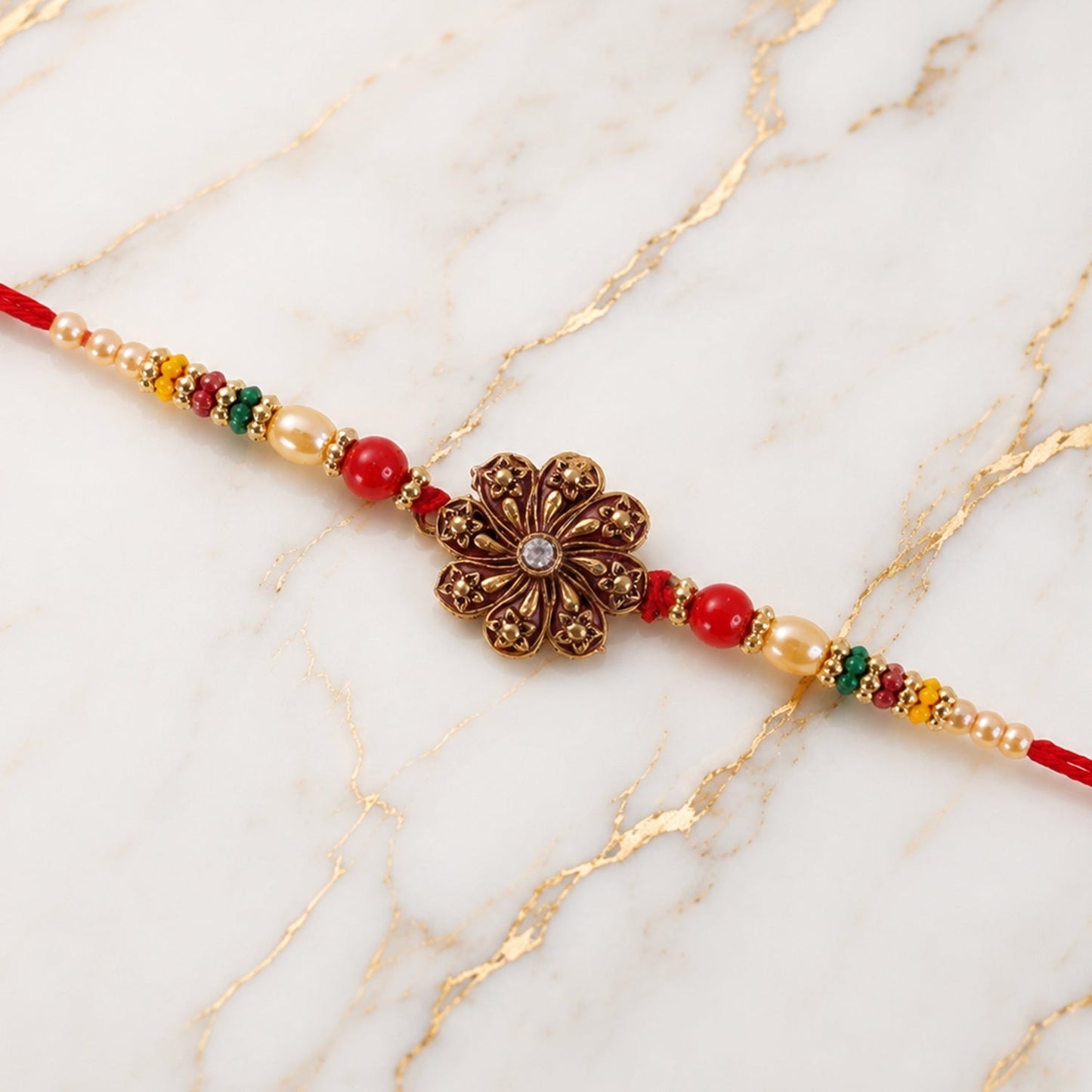 Side view of oxidised floral rakhi showing detailed thread work and bead embellishment