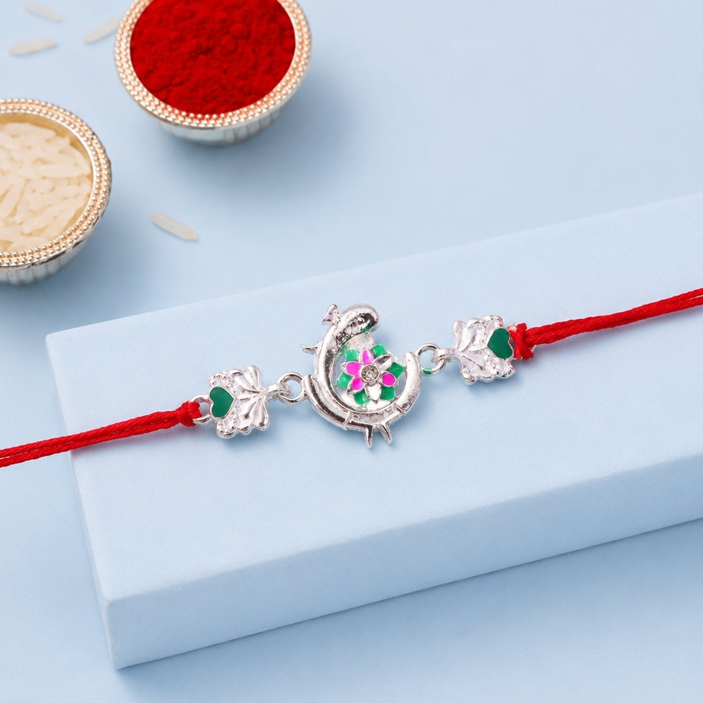 Stylish meenakari rakhi featuring traditional peacock design in bright colors