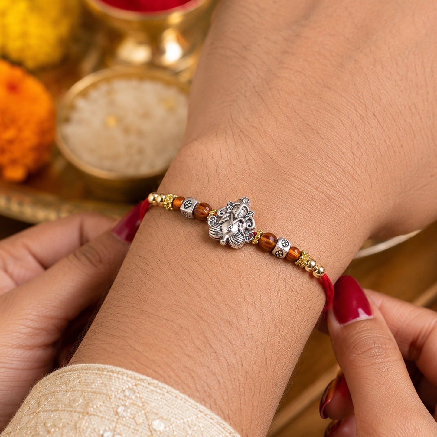 Decorative Silver Ganesha Rakhi with wooden beads, suitable for brothers