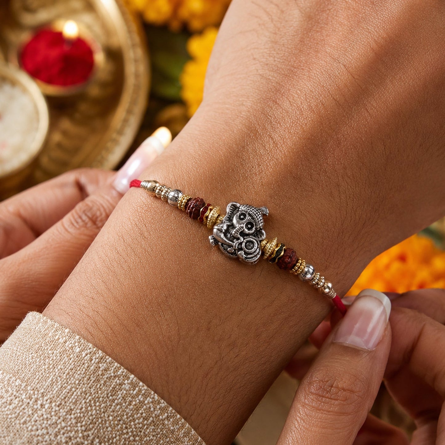 Decorative silver Ganesha Rakhi featuring Rudraksha for brother and sister