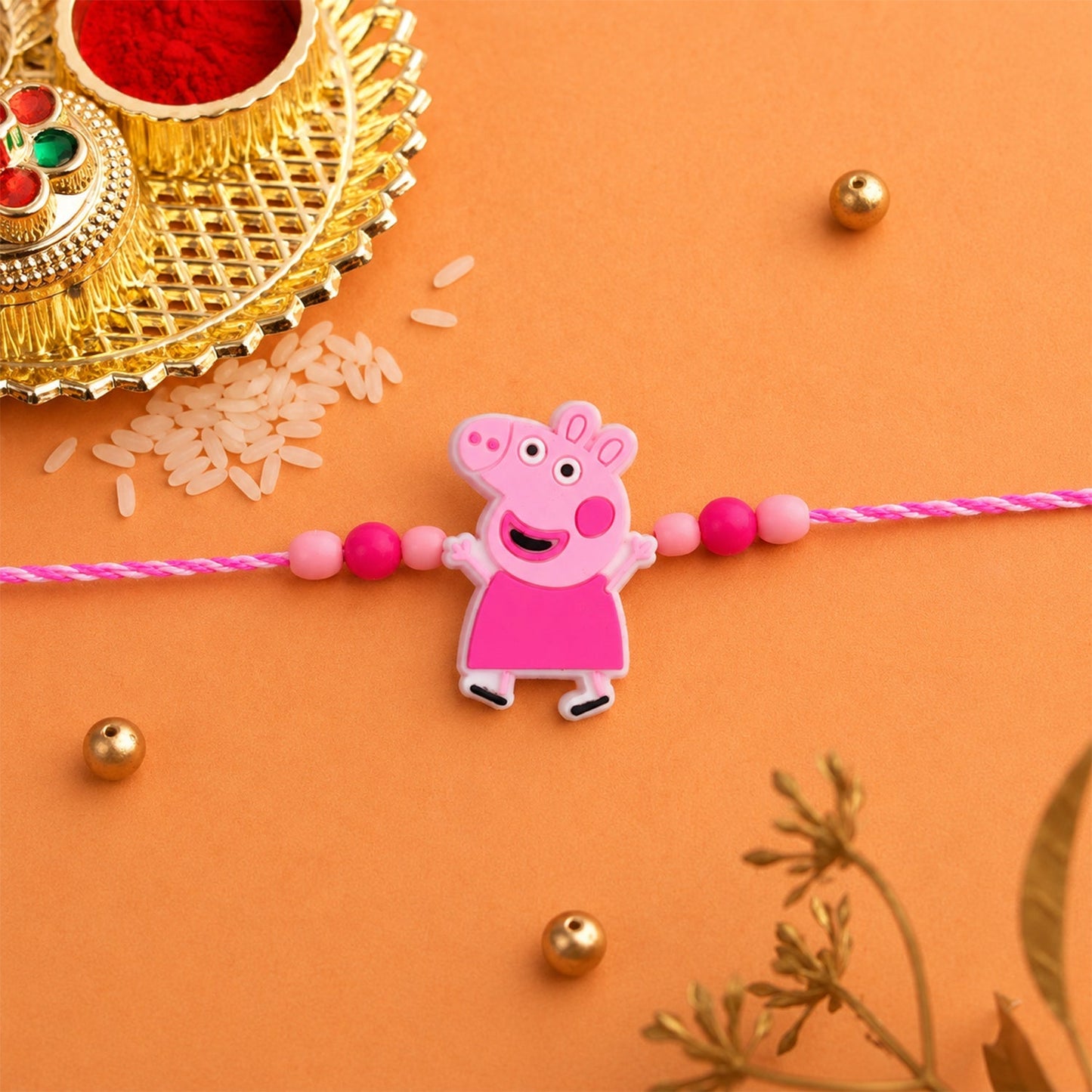 Angled view of kids' rakhi with cartoon character, pink decorative elements
