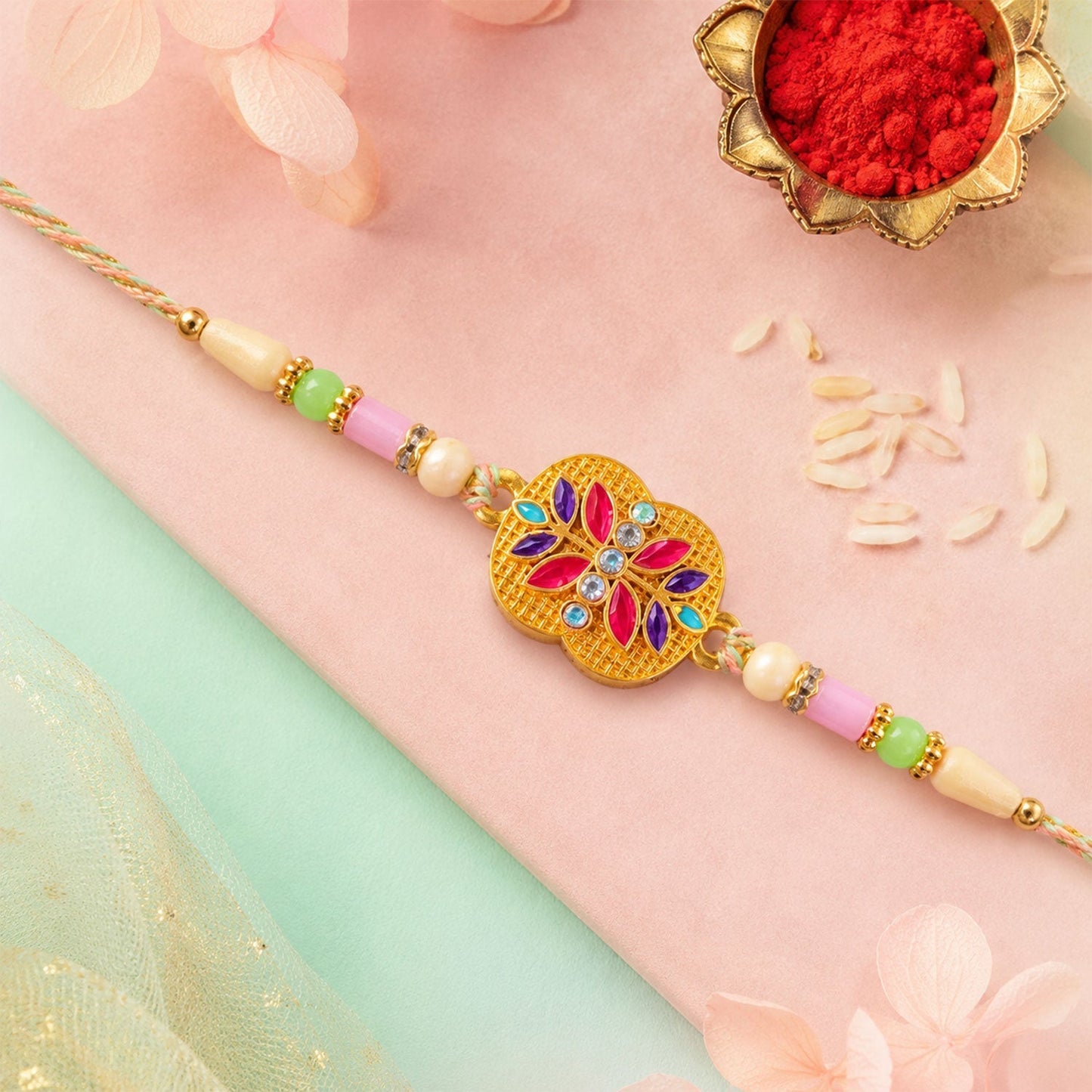 Stylish golden meenakari floral rakhi in a festive setting