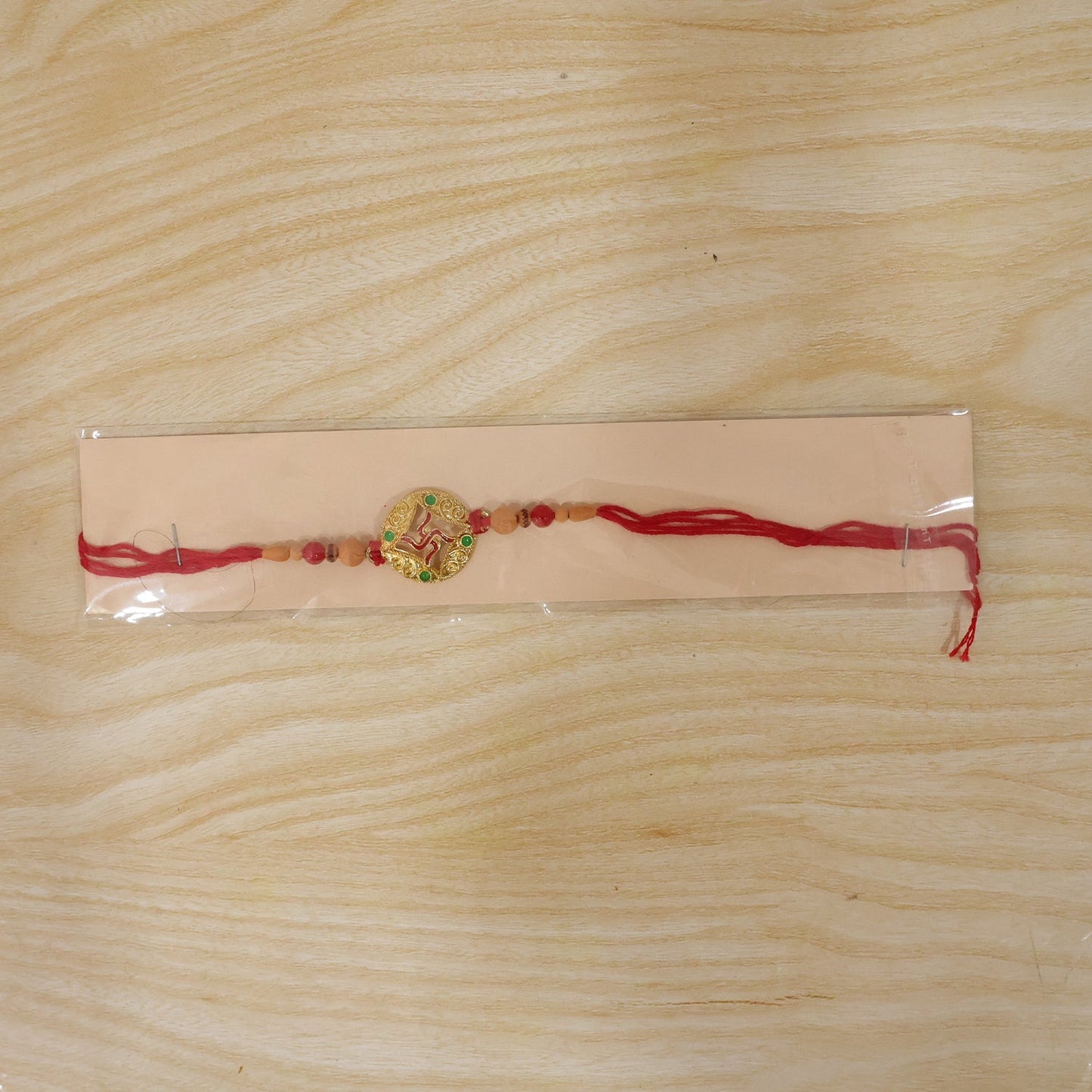 Festive rakhi featuring Swastik and traditional beads for brother