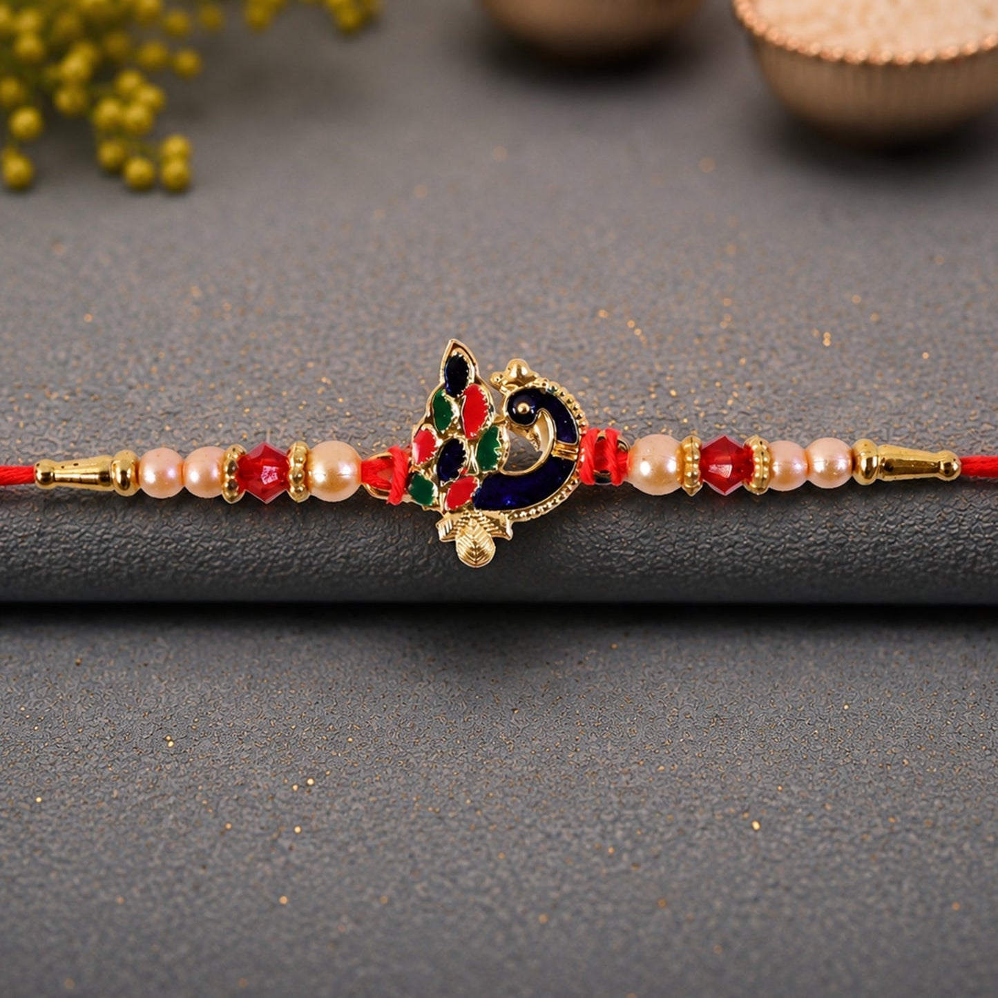 Stylish Blue Meenakari Rakhi featuring peacock motif with pearl embellishments