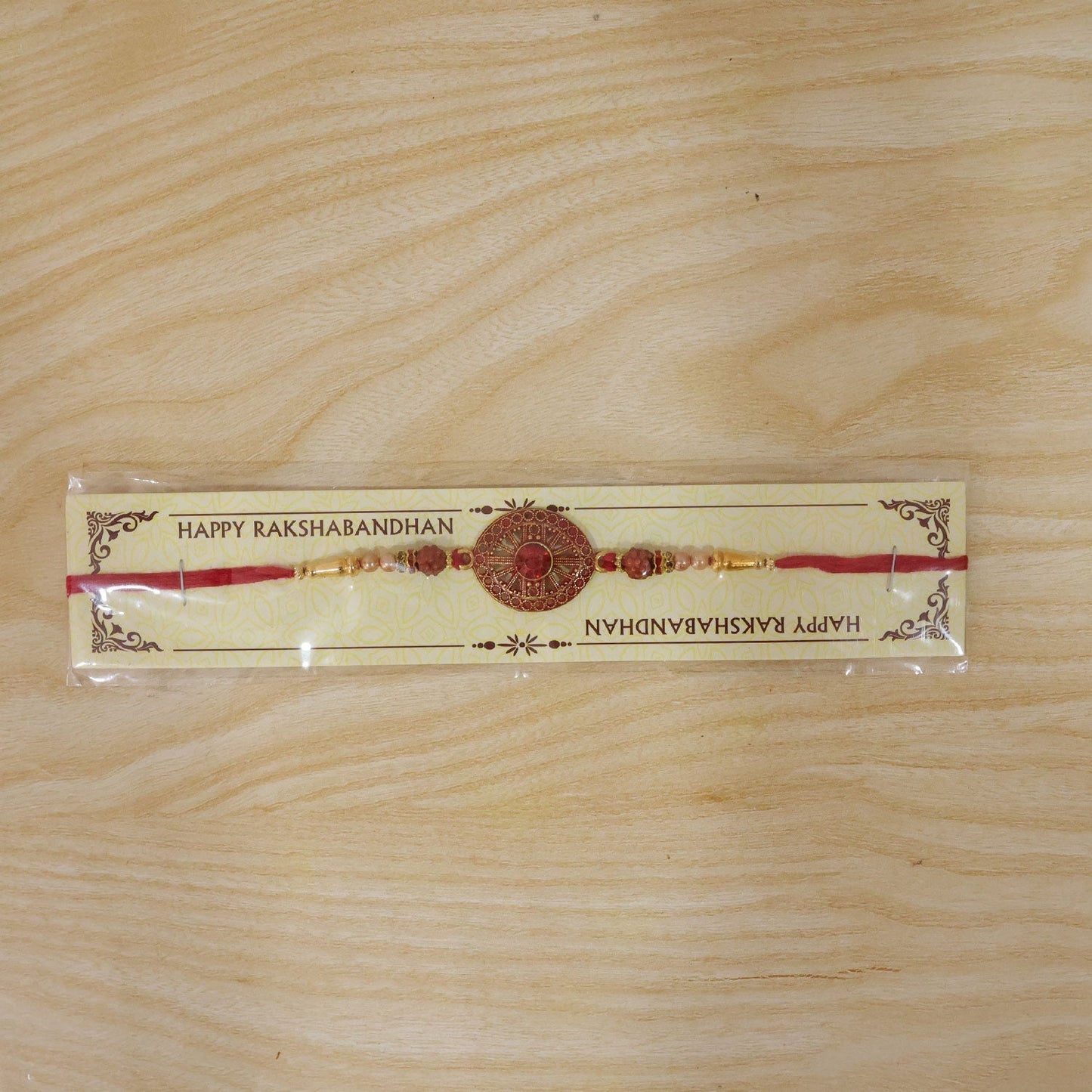 Premium designer Rakhi with red floral and crystal detailing