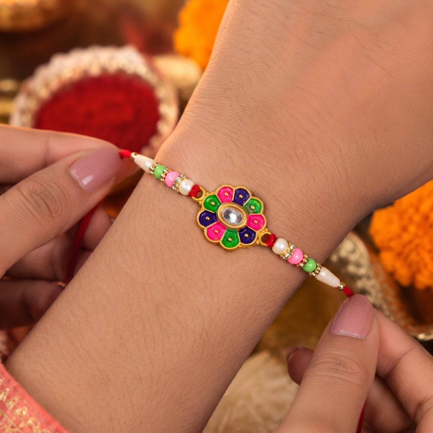 Close-up of floral stone and pearl bead rakhi detailing