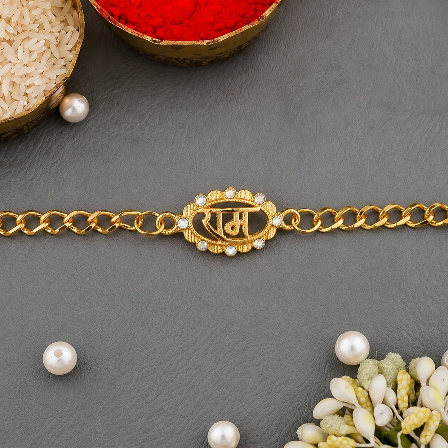 Close-up of the centerpiece of Ram Text Pearl Stone Rakhi bracelet with pearl and stone accents