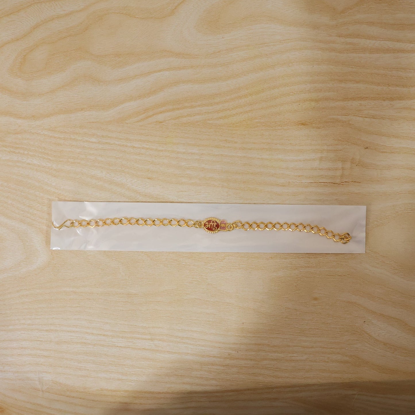 Decorative beads and thread detail on Bhai Rakhi with red enamel