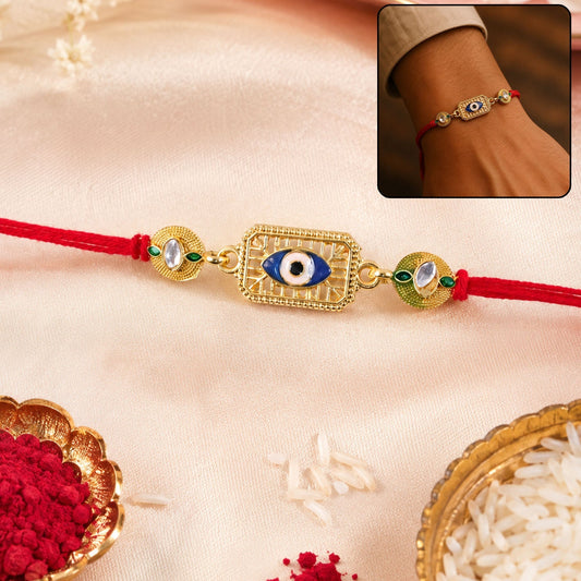 Close-up of evil eye stone-studded gold tone Rakhi for Rakshabandhan