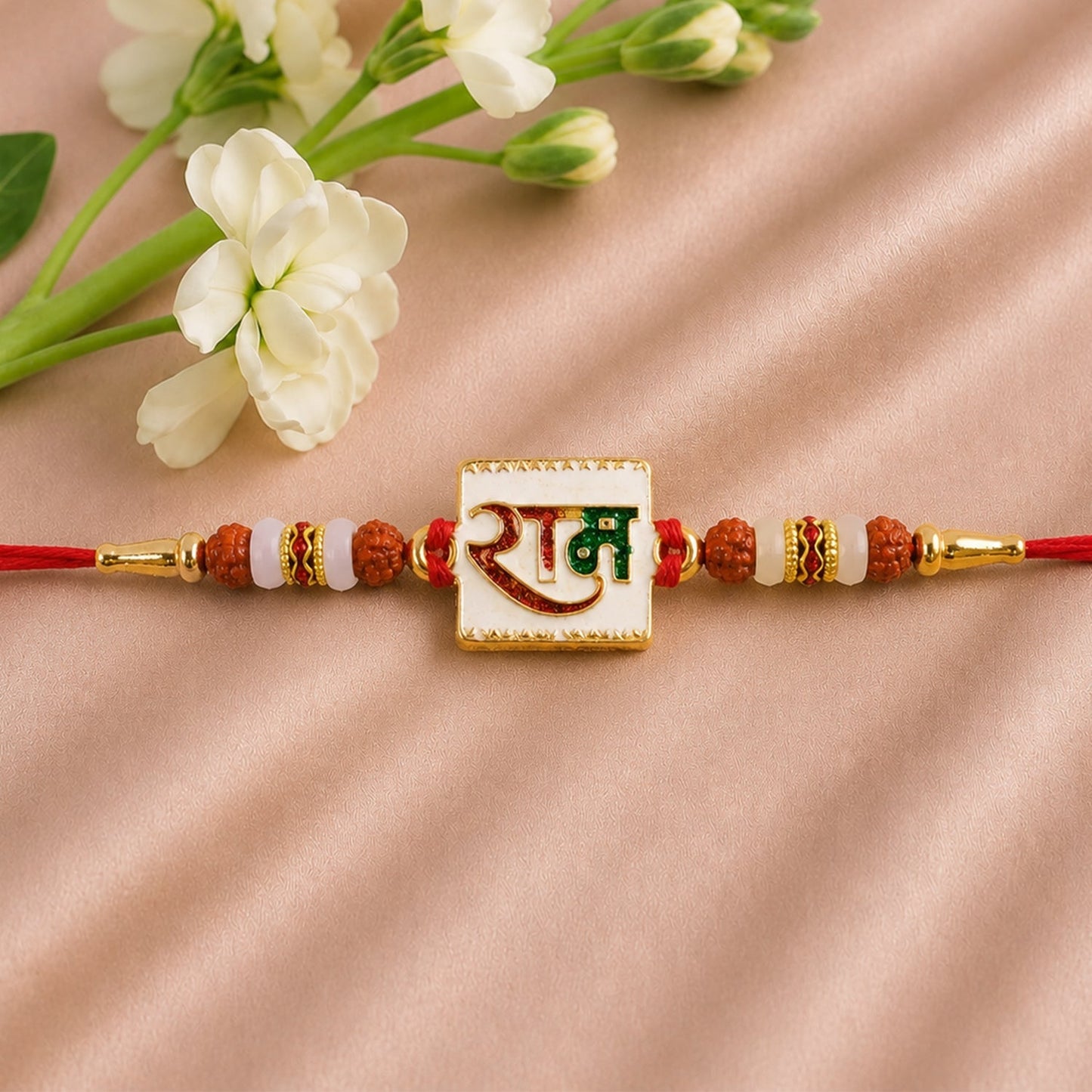 Angled view of Ram Text White Enamel Gold Tone Rakhi highlighting elegant finish