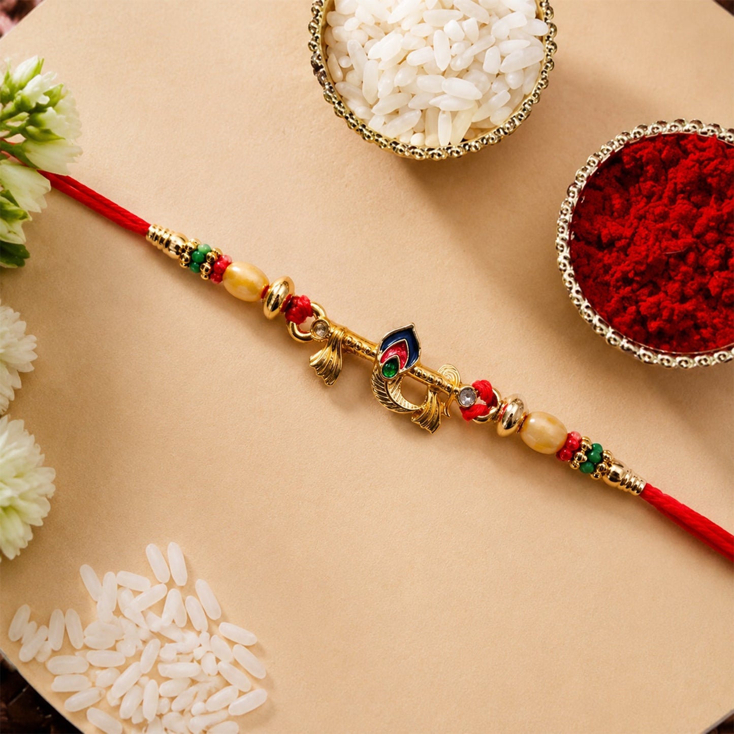 Close-up of gold tone peacock feather and multicolor beads on Rakhi