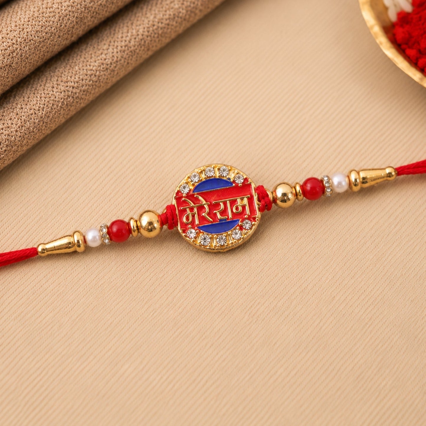 Gold tone Rakhi with stones on a white background