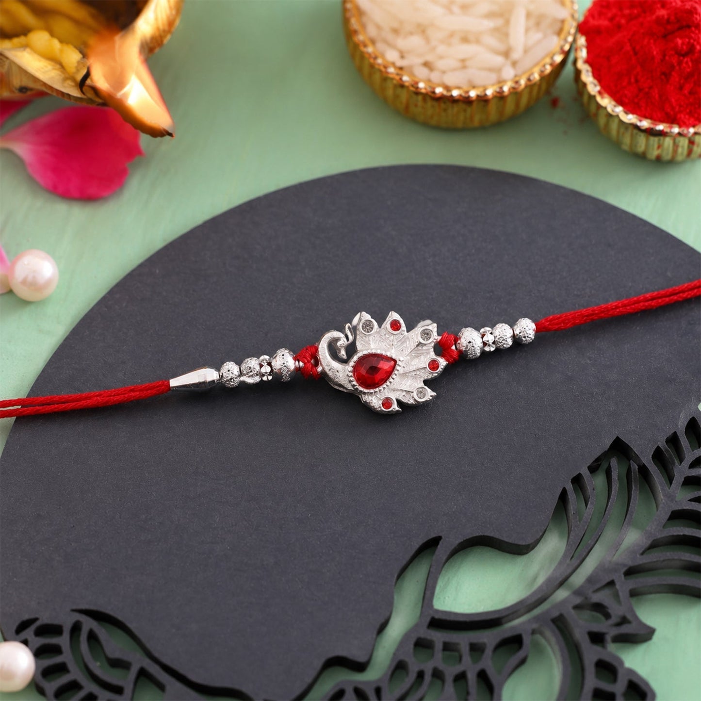 Close-up of Peacock Red Stone Rakhi showcasing intricate craftsmanship