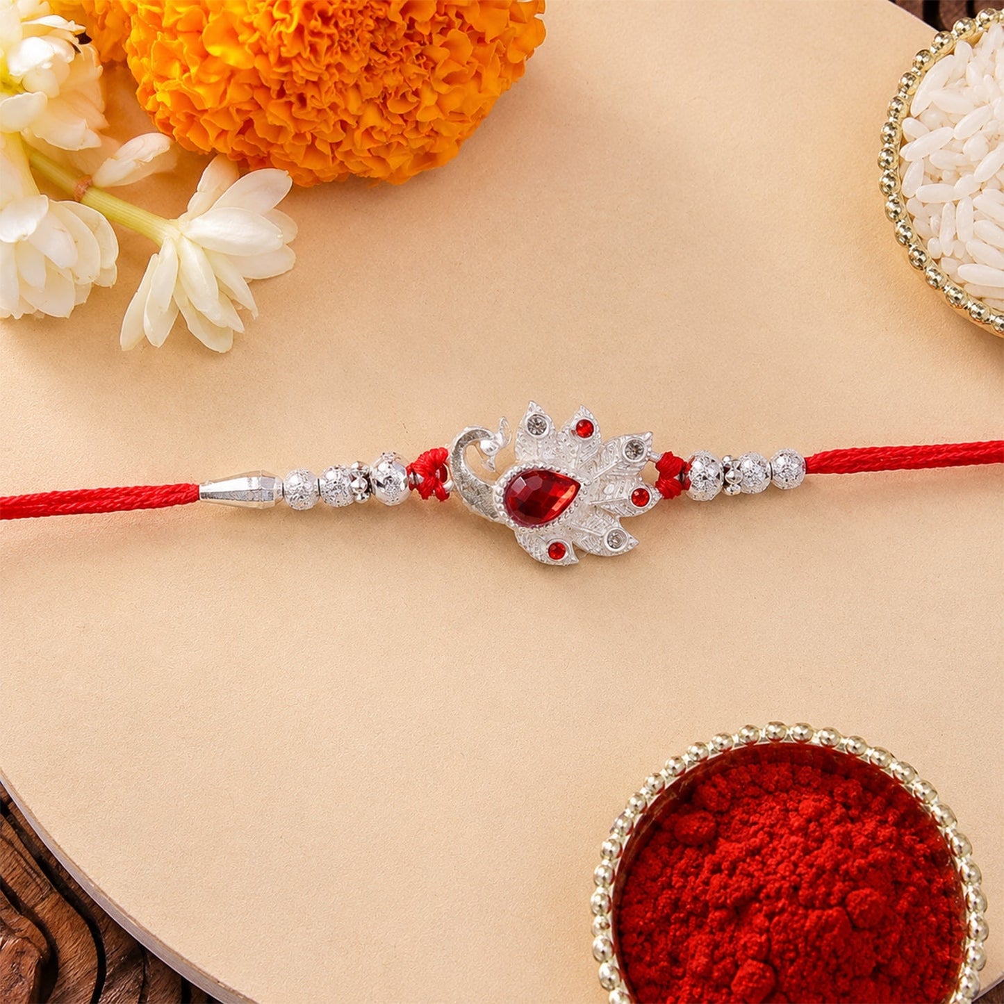 Stylish Peacock Rakhi with red stones for Rakshabandhan celebration