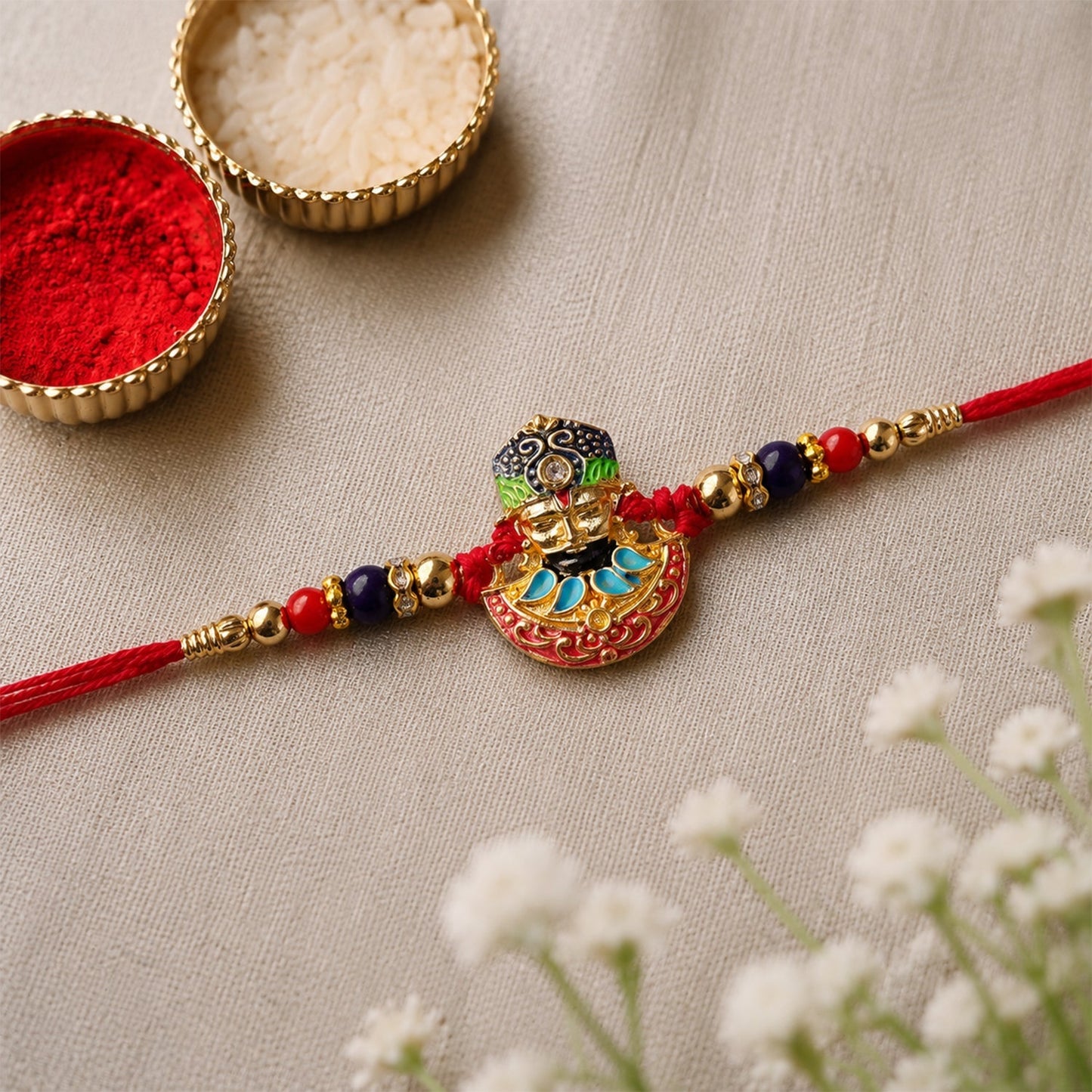 Attractive religious face enamel rakhi in festive colors, ideal for Rakshabandhan celebrations
