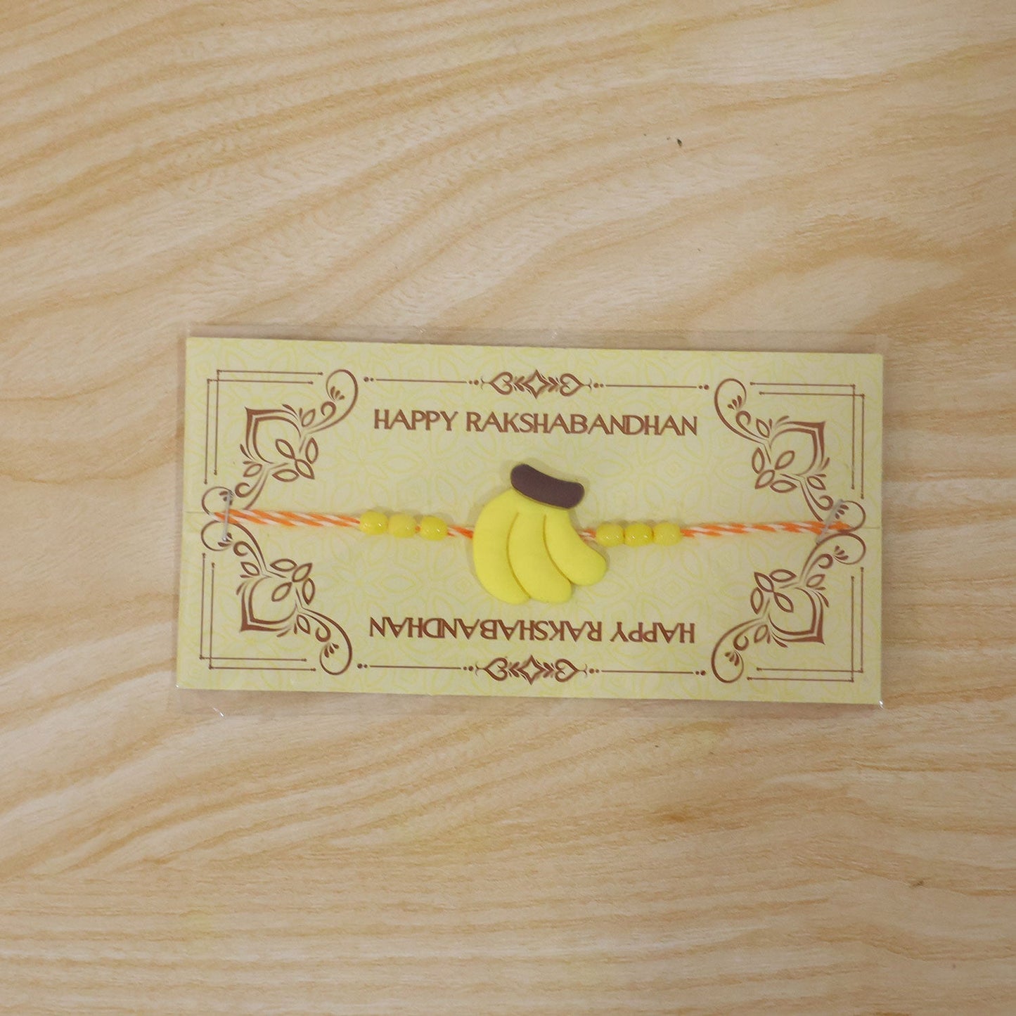 Front view of colorful yellow banana Rakhi for kids
