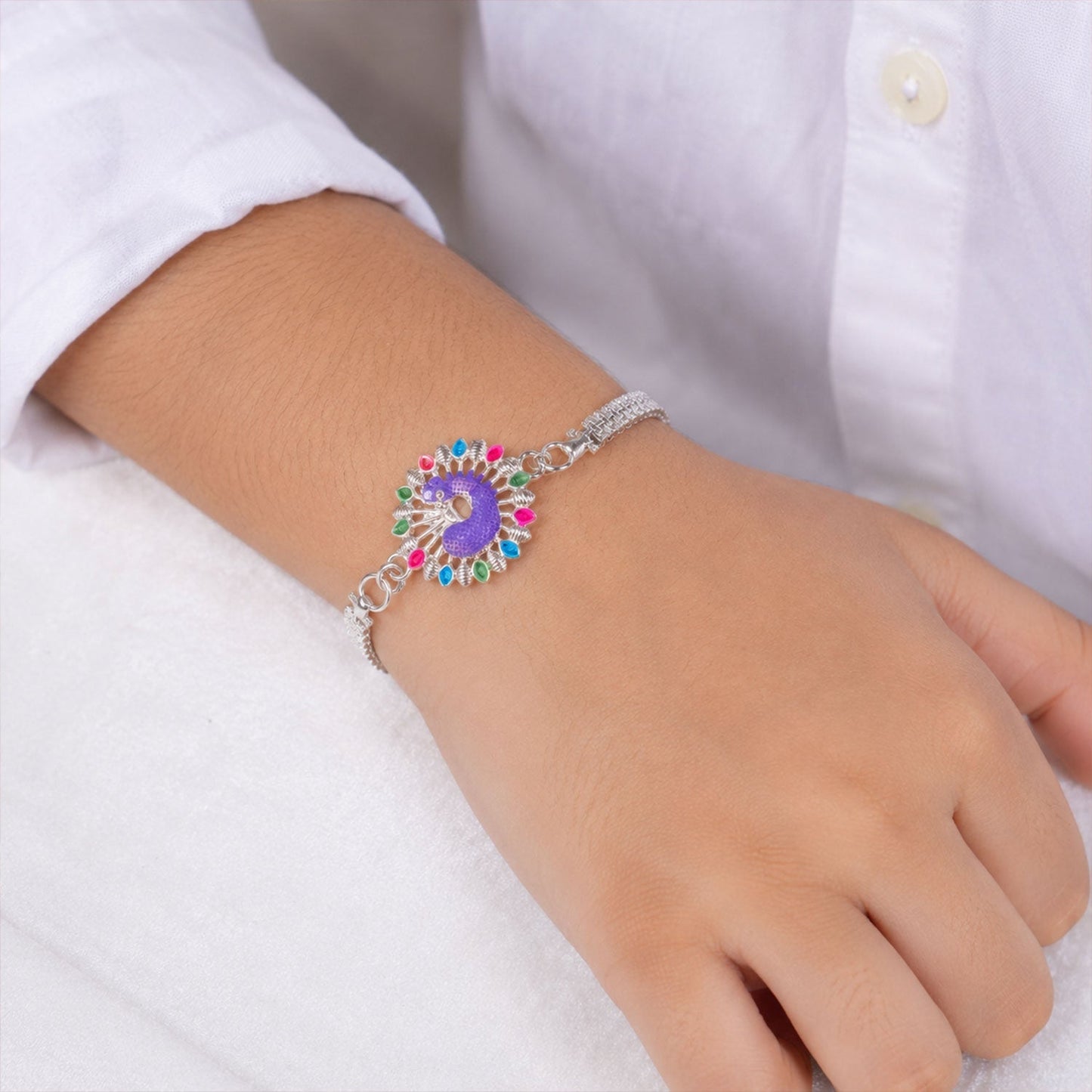 Festive Silver Peacock Rakhi featuring vibrant meenakari and traditional motifs