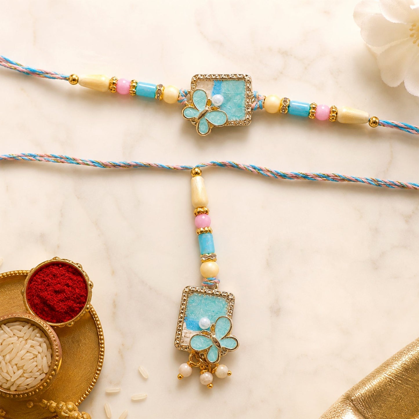 Turquoise floral Bhaiya Bhabhi Lumba Rakhi with pearls, front view