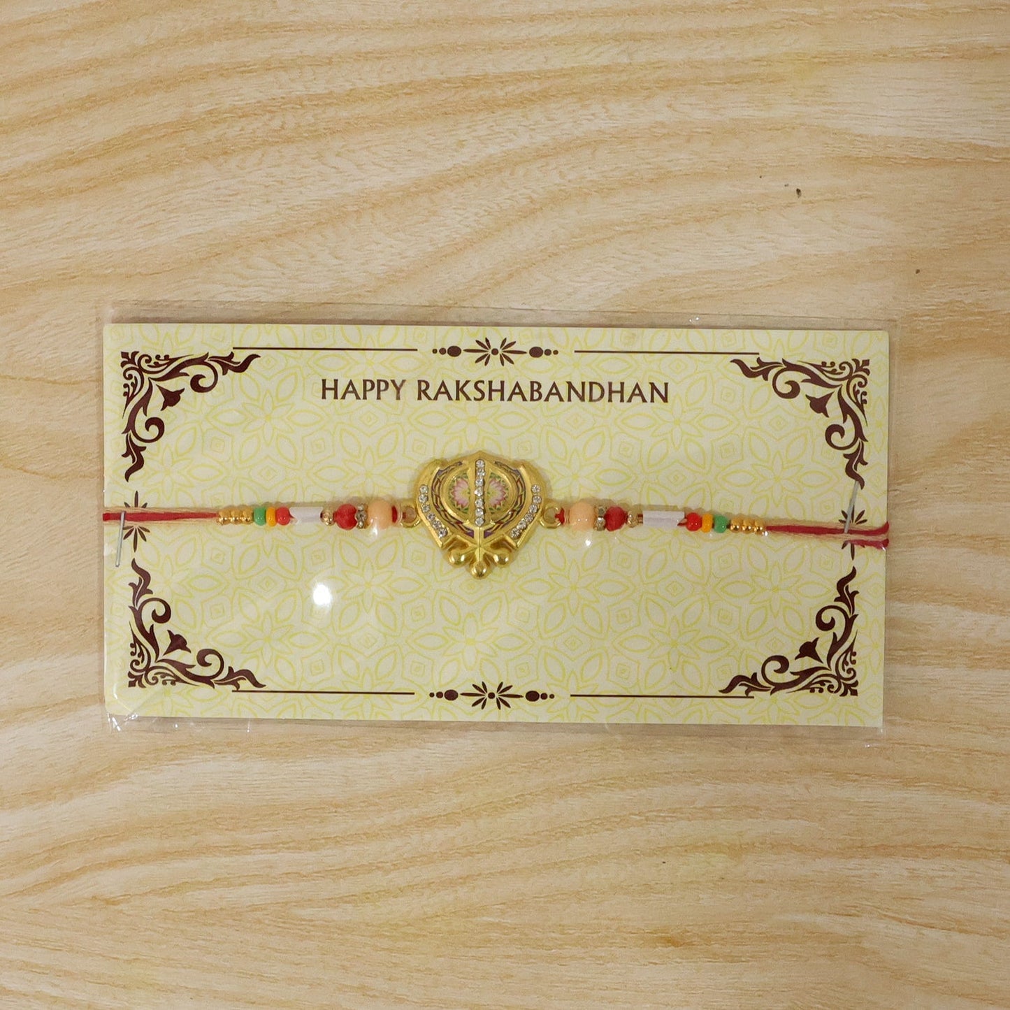 Back view of Khanda Rakhi showing secure symbol attachment.