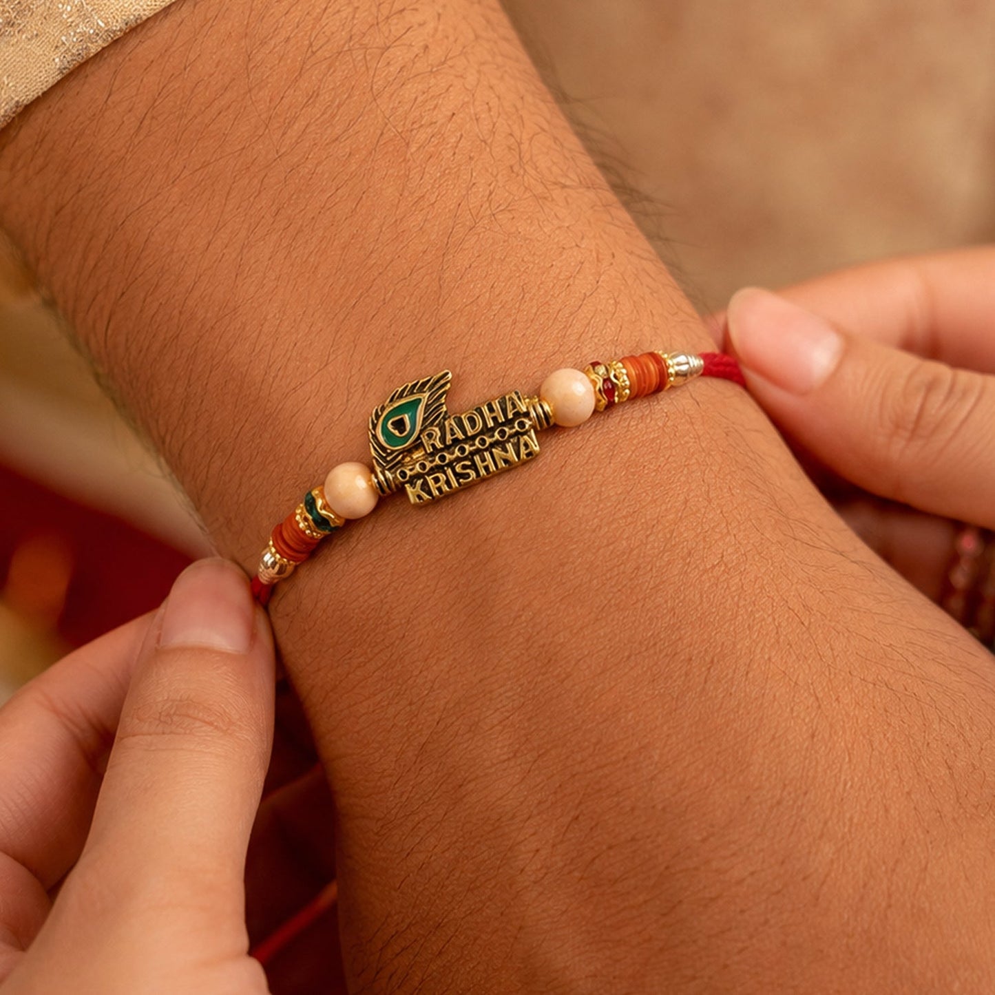 Elegant traditional Rakhi featuring peacock feather and gold-tone accents for Raksha Bandhan