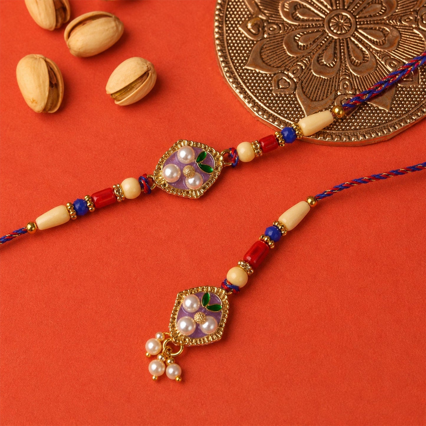 Festive elegant rakhi with pearl, enamel, and sparkly stones