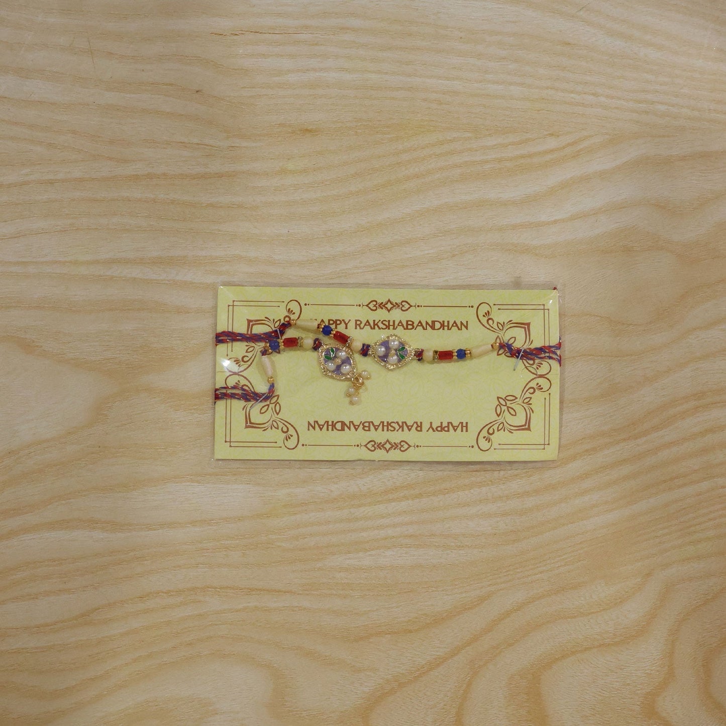 Vibrant rakhi featuring pearls, enamel, and sparkling stones