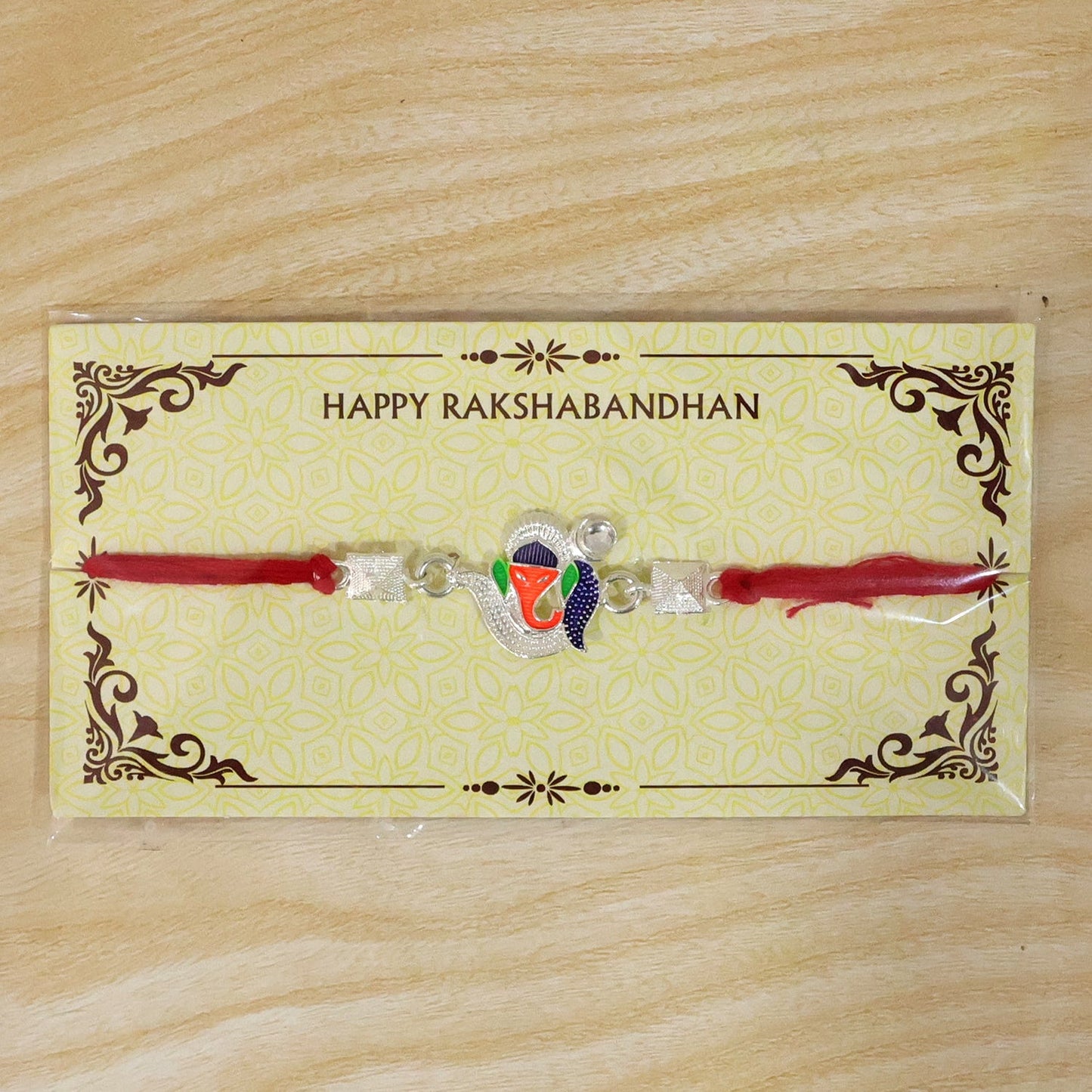 Festive Silver Ganesha Rakhi with enamel work for brother-sister occasion