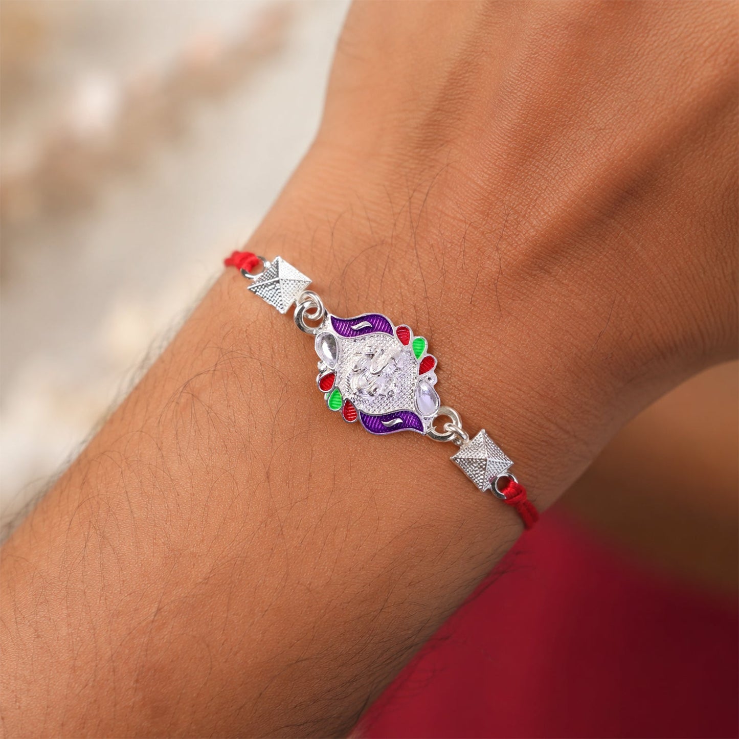Close-up of multicolor enamel pyramid bead design on Ganesha Rakhi