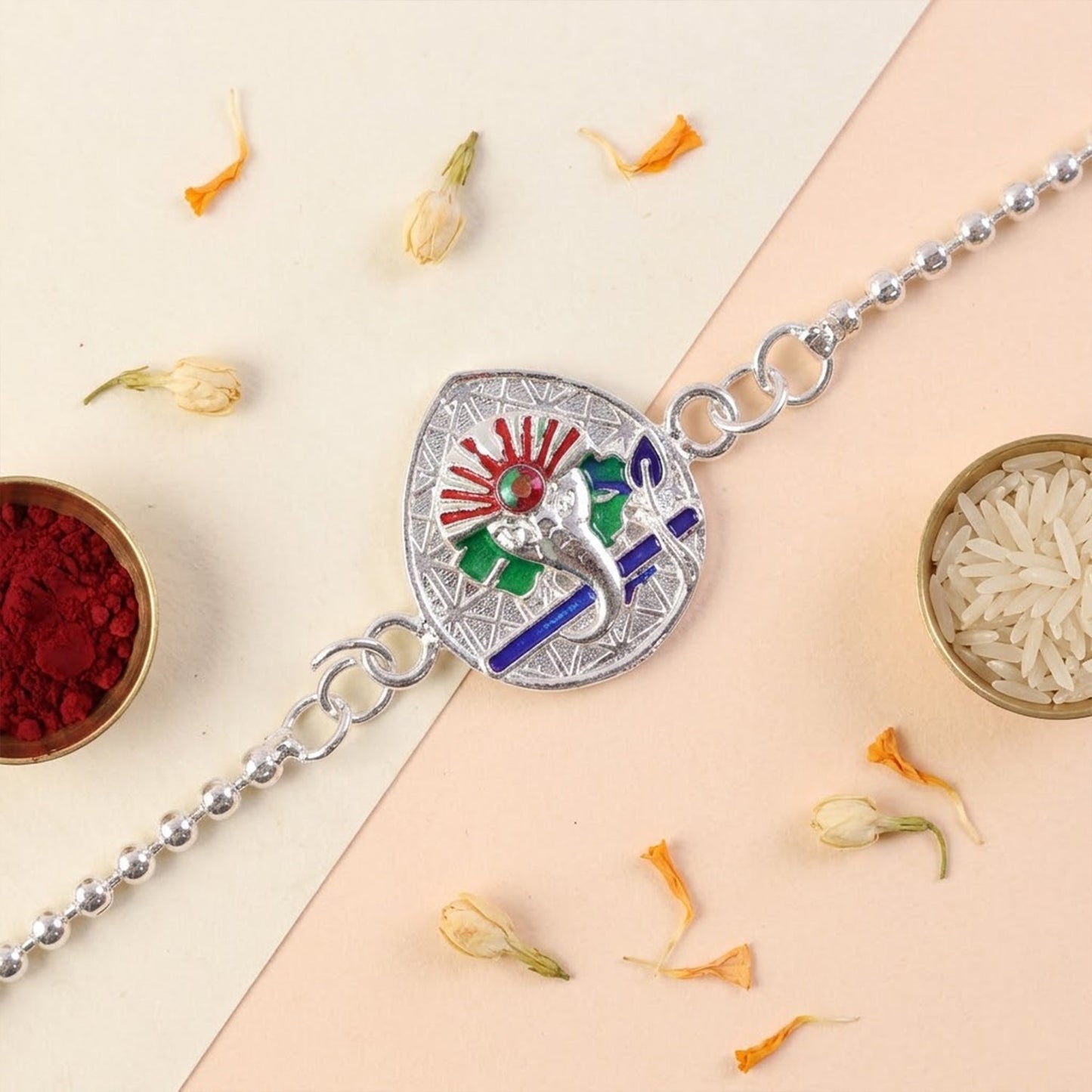 Elegant enamel Ganesha charm bracelet rakhi displayed with other festive Rakhis