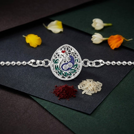 Peacock teardrop enamel charm chain bracelet Rakhi displayed as a festive accessory