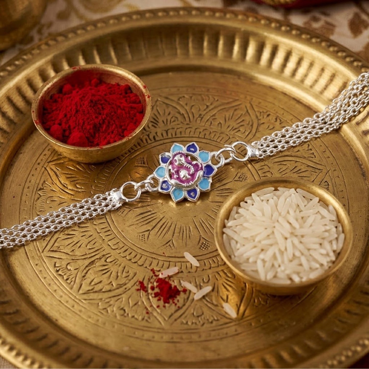 Decorative Lord Ganesha Rakhi with floral petals, perfect for siblings
