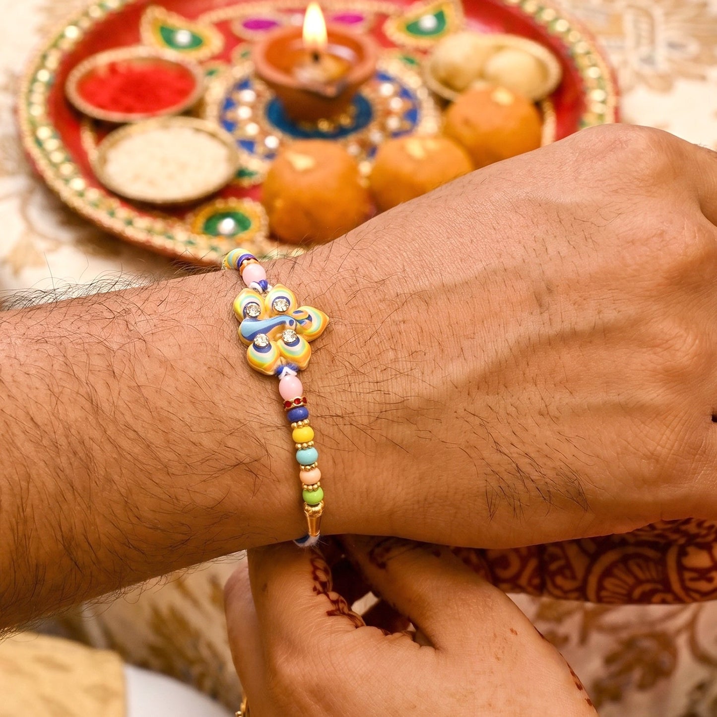Golden swirl centerpiece with beads on traditional Rakhi